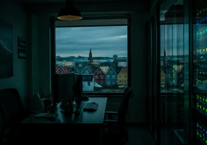 A dark office looking out over colourful houses